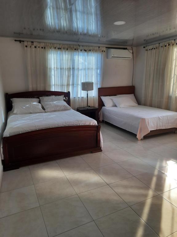 um quarto com 2 camas e piso em azulejo em VILLA MARIA em Turbaco
