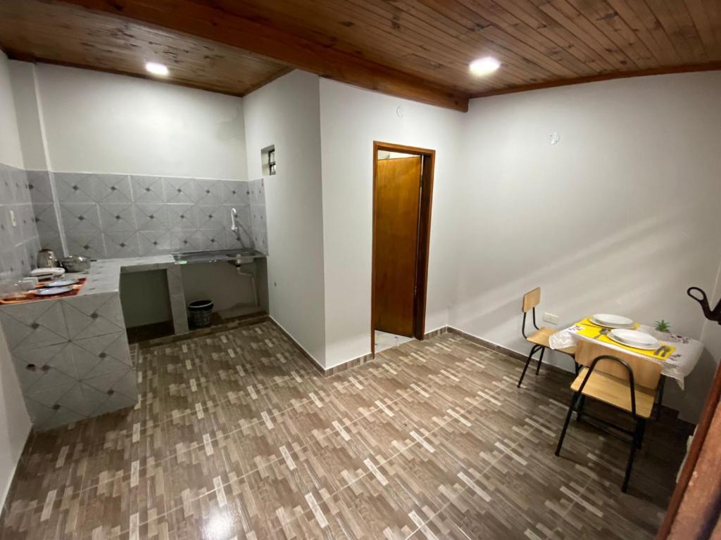 um quarto com uma mesa e uma mesa e uma cozinha em Apartamentos IVAGO em Encarnación