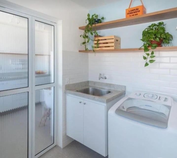 uma cozinha branca com um lavatório e um balcão em recanto do aconchego em Contagem