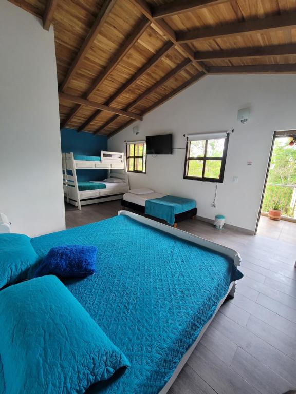sypialnia z dużym łóżkiem z niebieską pościelą w obiekcie La Posada de La Abuela Salento w mieście Salento