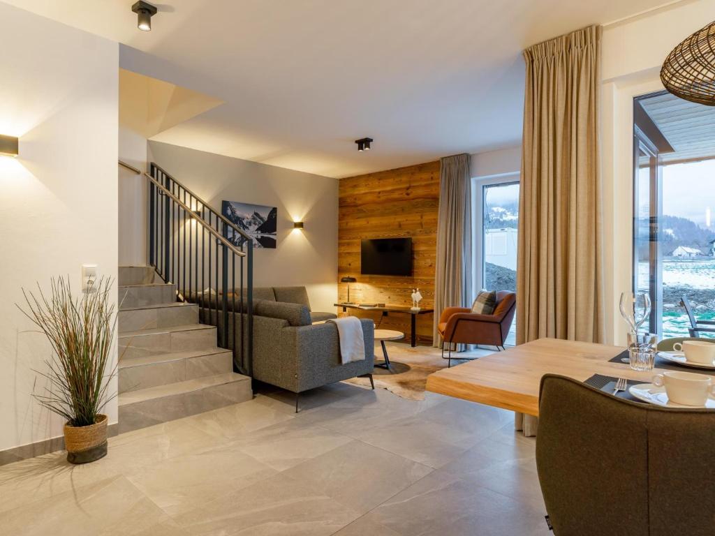 a living room with a staircase and a couch and a table at Mountain Chalet Chapeau in Sankt Lorenzen ob Murau