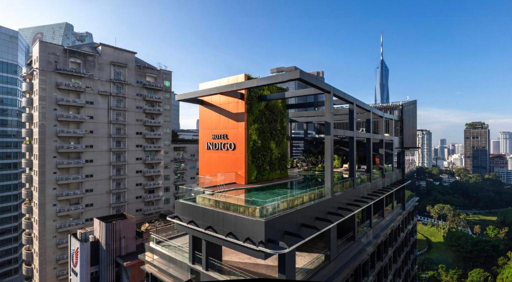 A rooftop pool terrace sits beside the hotel with a prominent city skyline behind it.
