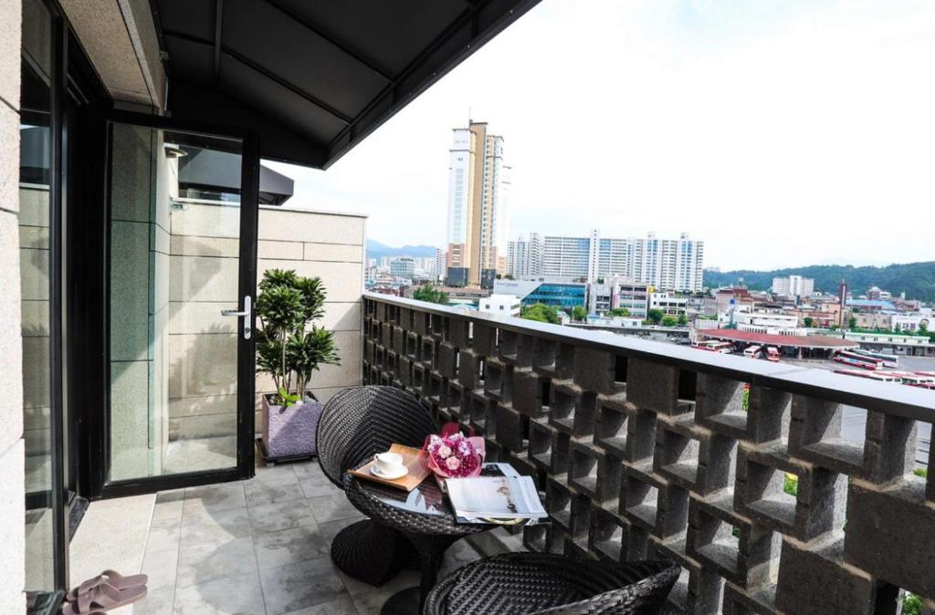 una mesa en un balcón con vistas a la ciudad en Mari Hotel Terminal Branch, en Jeonju
