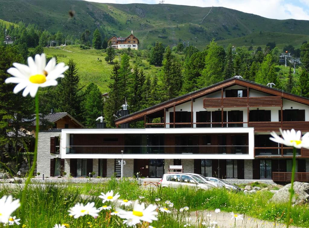 un edificio con un campo de flores delante de él en Apparthotel Silbersee en Turracher Hohe