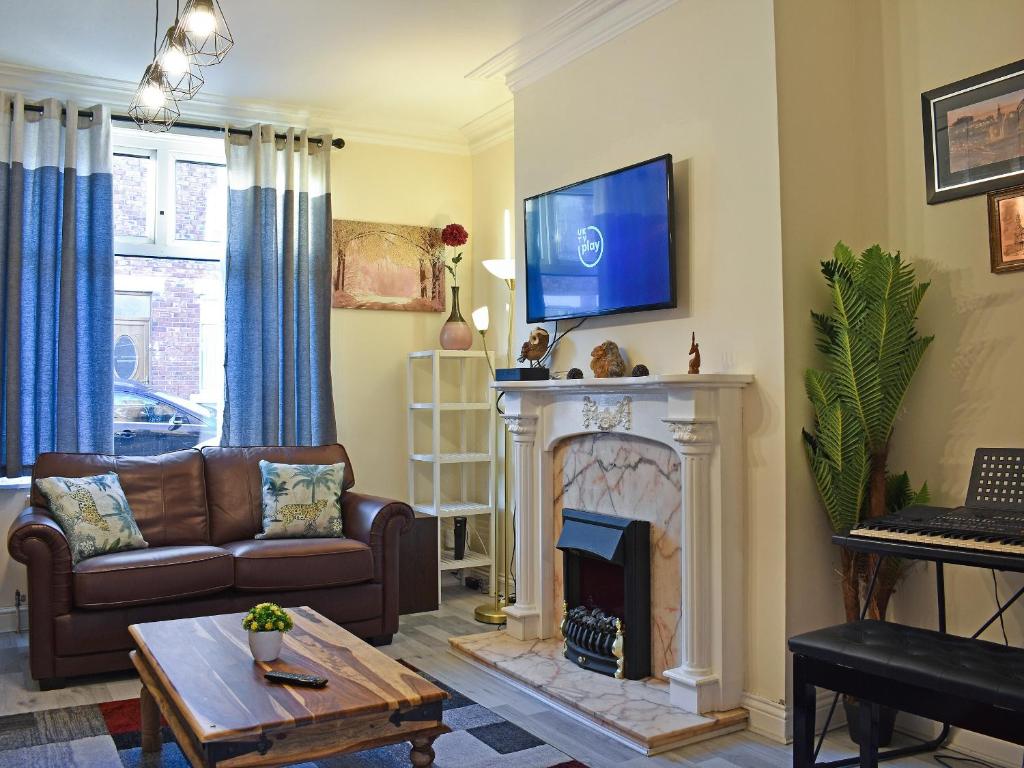 a living room with a couch and a fireplace at Seymour House in Bishop Auckland
