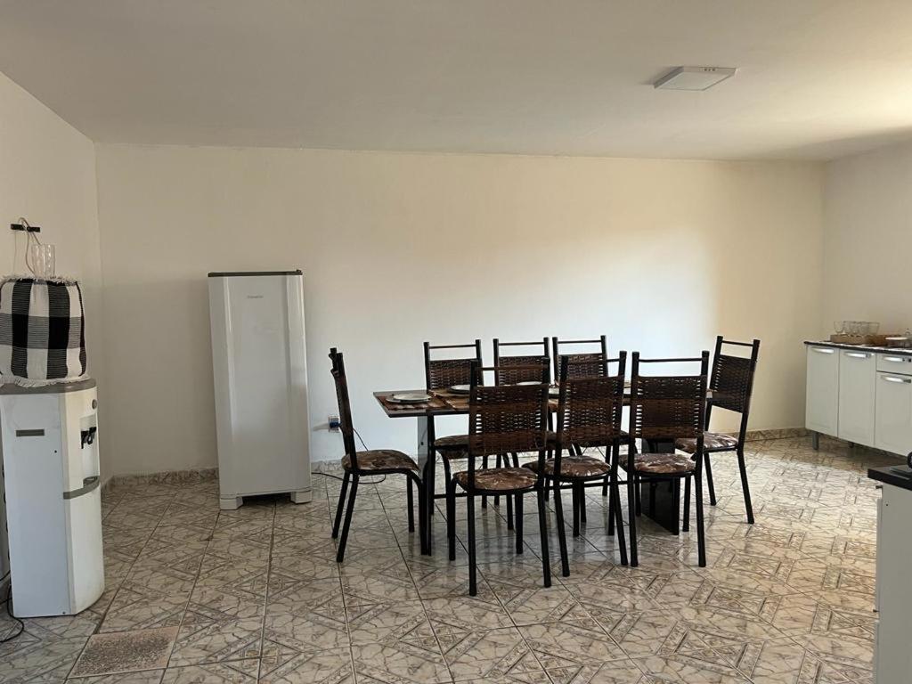 a dining room with a table and chairs and a refrigerator at Casa Sertão Xingó in Piranhas