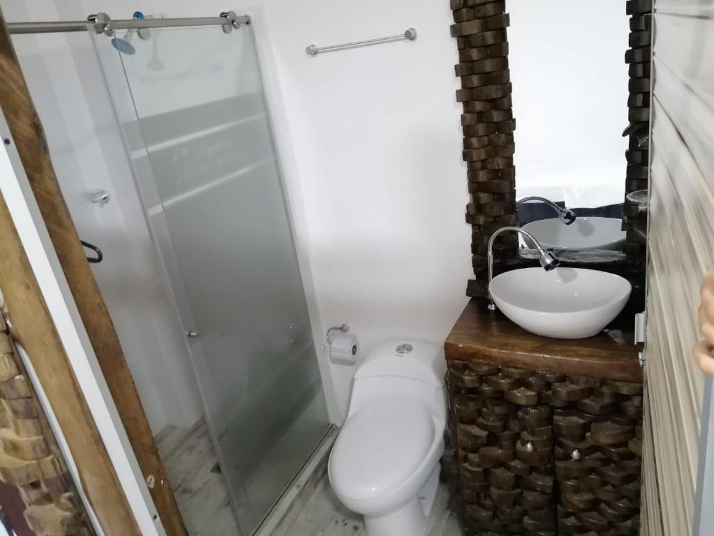 a bathroom with a toilet and a sink at Hotel Ambeyma in Garzón