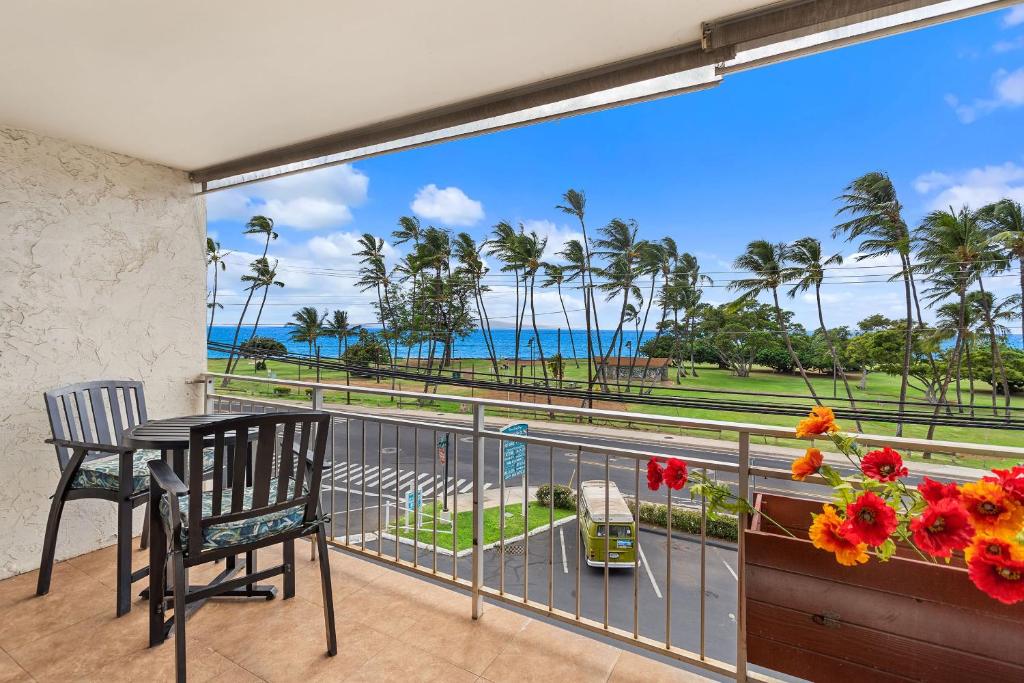 a balcony with a table and chairs and a view of the ocean at Island Surf 304 - Renovated, Ocean Views, Split AC in Kihei