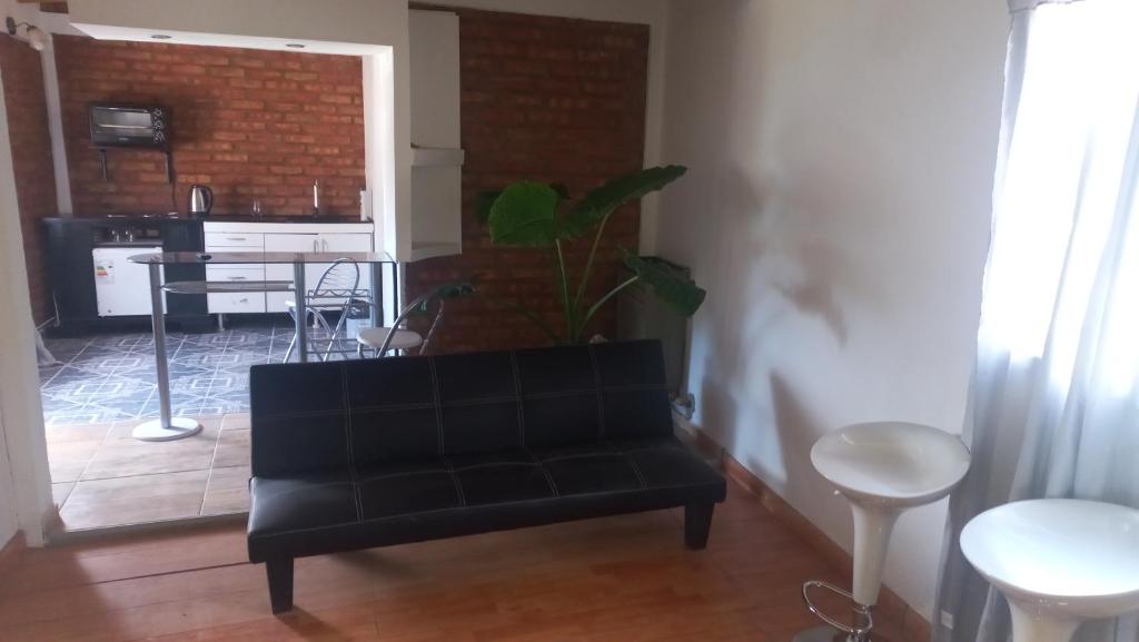 uma sala de estar com um sofá preto e uma mesa em Dpto rosales em Los Antiguos