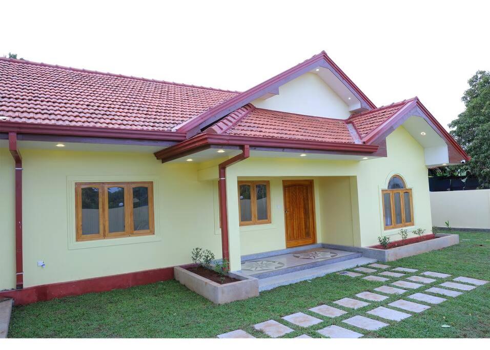 een klein huis met een rood dak bij Lone Star Residence in Jaffna