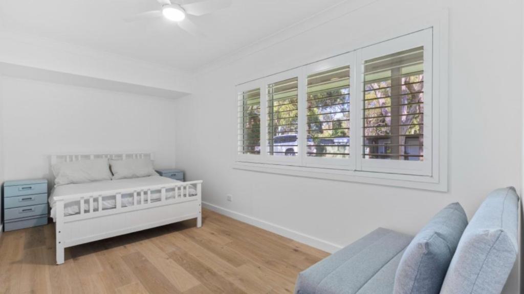 a white room with a bed and a window at 60 Yamba Street Hawks Nest in Sydney