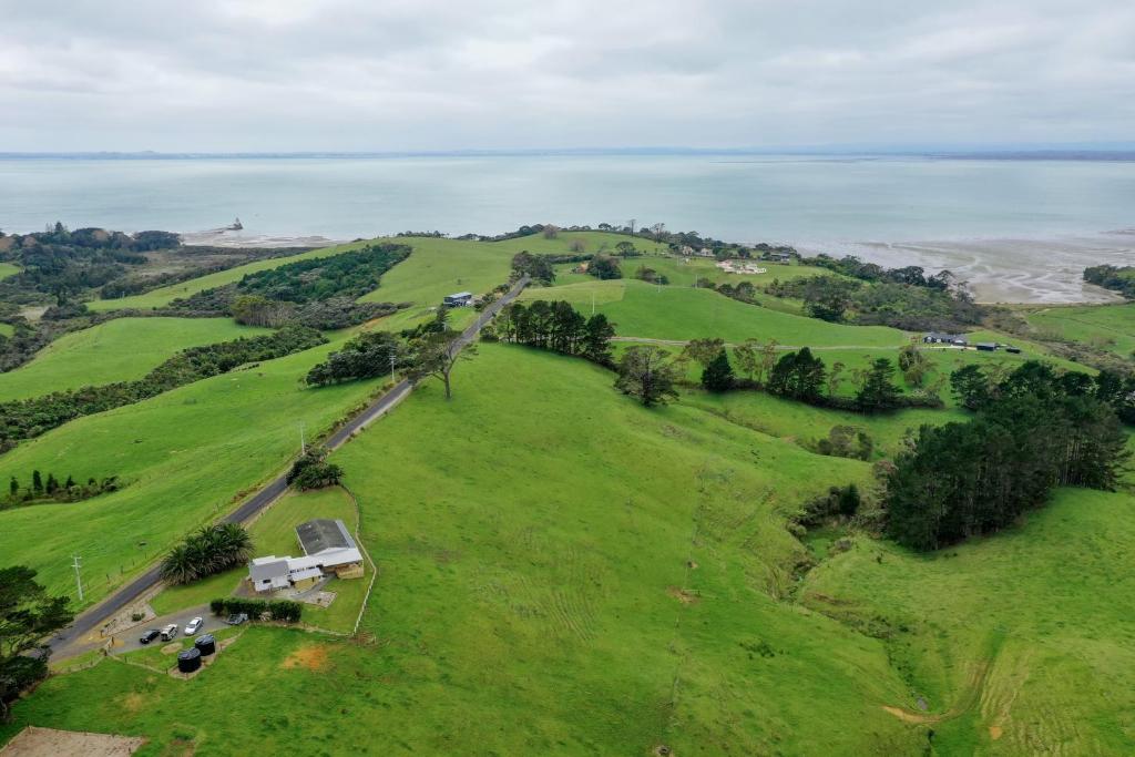 an aerial view of a green field with a farm at Apartment 4 in Auckland
