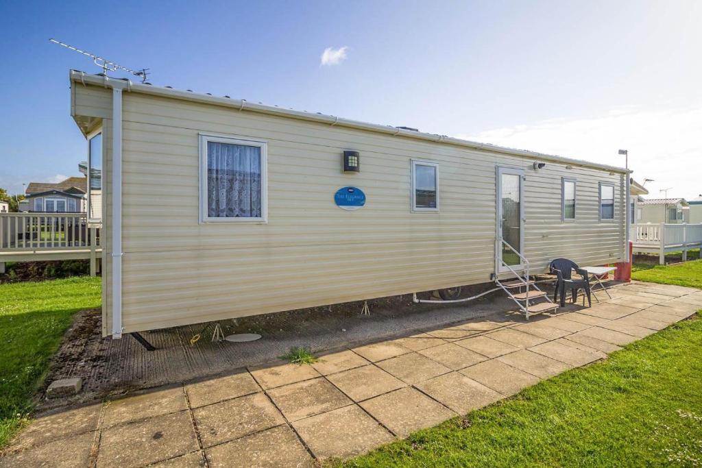 a tiny house on a patio in a yard at 8 Berth Spacious Caravan By The Beach In Norfolk Ref 50059g in Great Yarmouth
