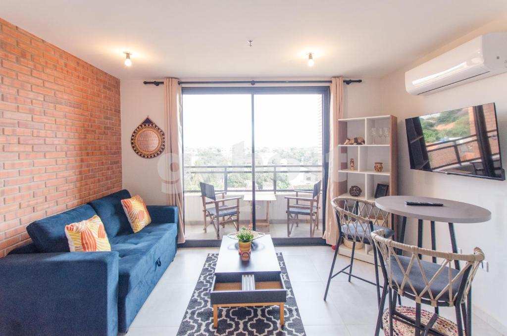 a living room with a blue couch and a brick wall at Comfortable Los Laureles Loft in Asunción