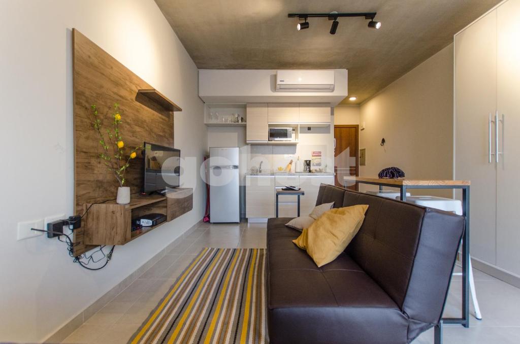a living room with a couch and a kitchen at Comfy Loft Bbq Terrace And Balcony in Asuncion