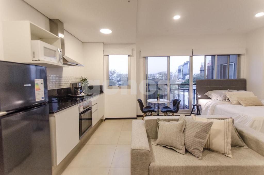 uma cozinha e sala de estar com uma cama e um sofá em Wonderful Studio In The City, Close To Sh Del Sol em Assunção