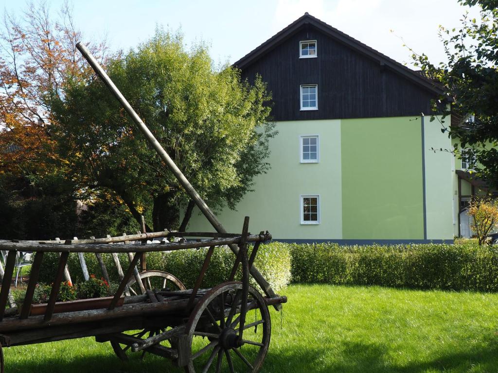 une voiturette tirée par un cheval devant une maison dans l'établissement Rennsteighotel Herrnberger Hof, à Neuhaus am Rennweg