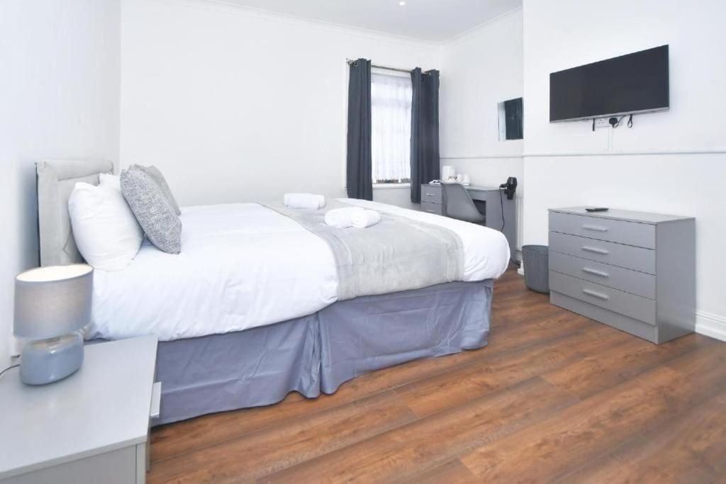 1 dormitorio con 1 cama y vestidor con TV en The Green House, en Stoke on Trent