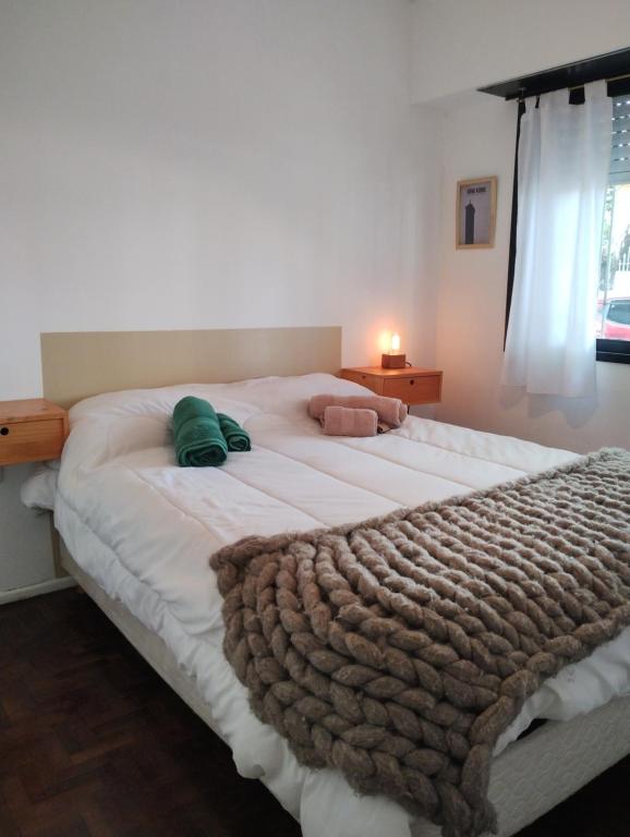 ein Schlafzimmer mit einem großen weißen Bett mit einer Decke in der Unterkunft Una casita en la loma in La Plata