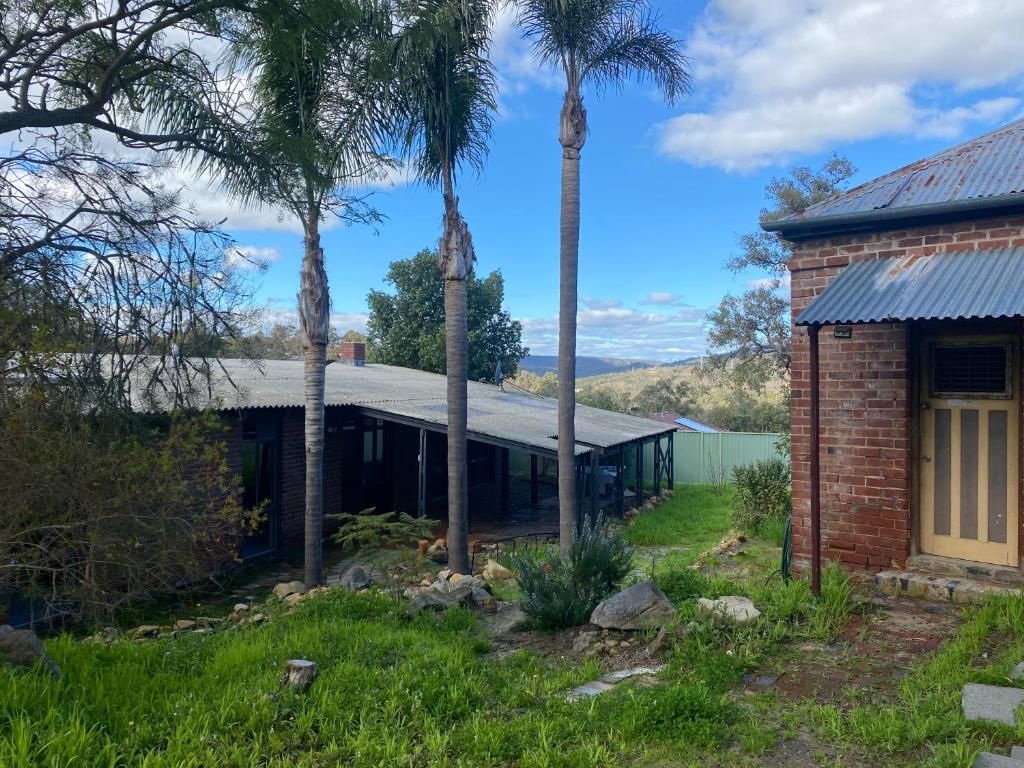 een stenen huis met palmbomen ervoor bij Tranquil home in hills with city views 