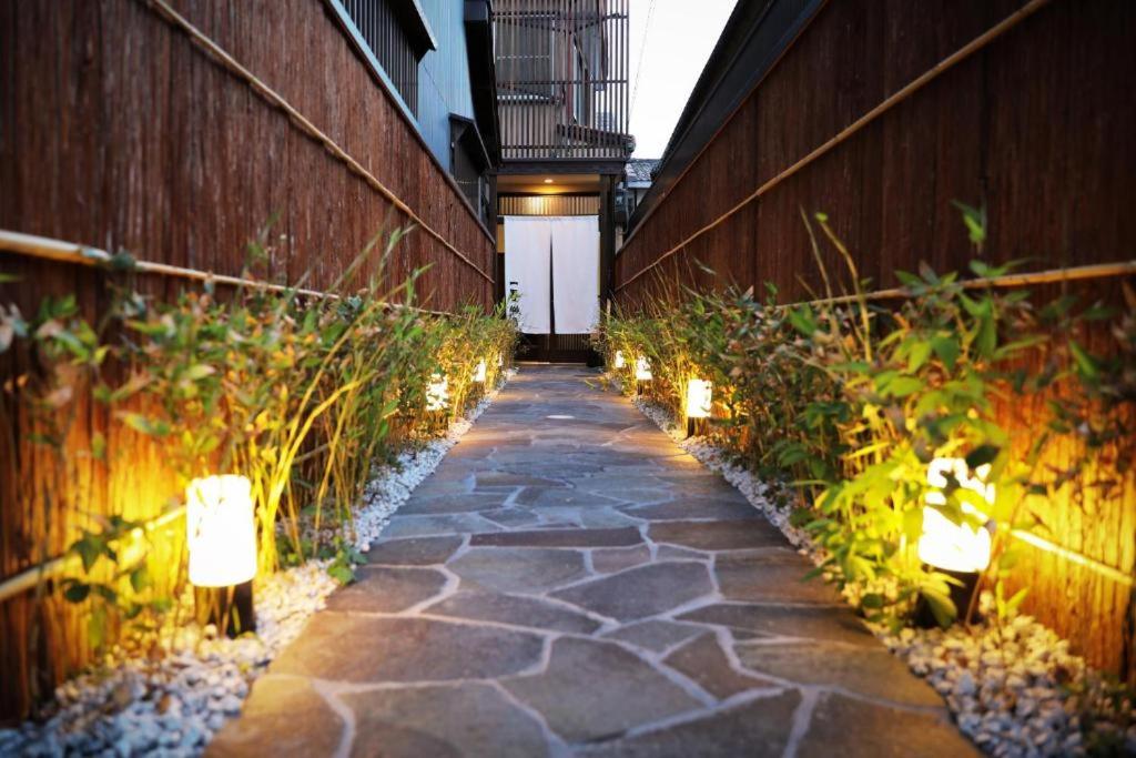 einen Gehweg mit Lichtern an der Seite eines Gebäudes in der Unterkunft 一吾山房 in Kyoto