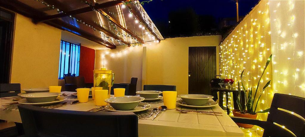 Casa Cielo en Paipa Centro في بايبا: طاولة عليها صحون وصحون مع أضواء