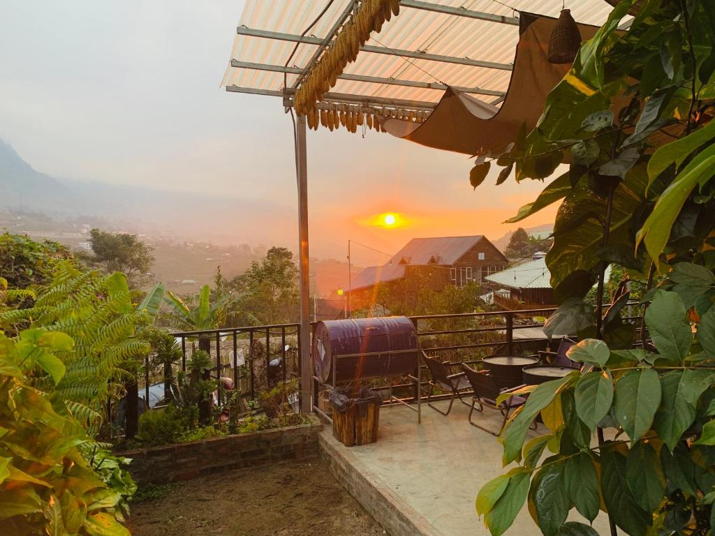 a balcony with a sunset in the background at Plum Eco House in Sapa