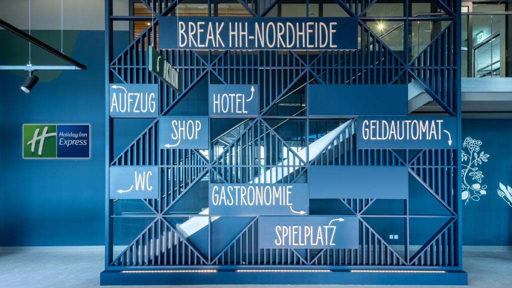 eine Wand von Schildern in einem Gebäude in der Unterkunft Holiday Inn Express - Hamburg South A7-AS42, an IHG Hotel in Egestorf