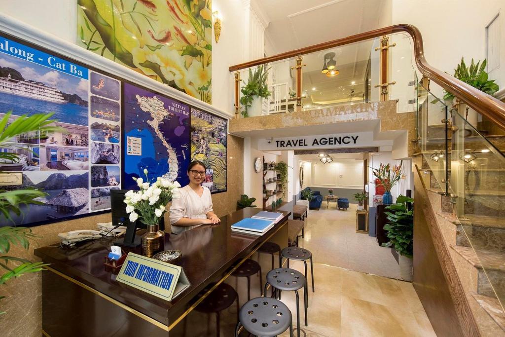 a woman is sitting at a counter in a lobby at Hortensia Flower in Hanoi