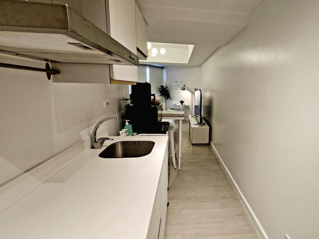 uma cozinha com um lavatório e uma bancada em Cozy Condo with City View em San Fernando