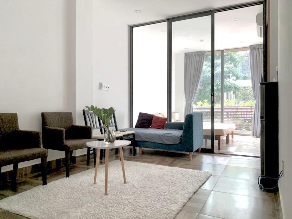 a living room with a couch and chairs and a table at PJ Hotel & Apartment - Thao Dien in Ho Chi Minh City