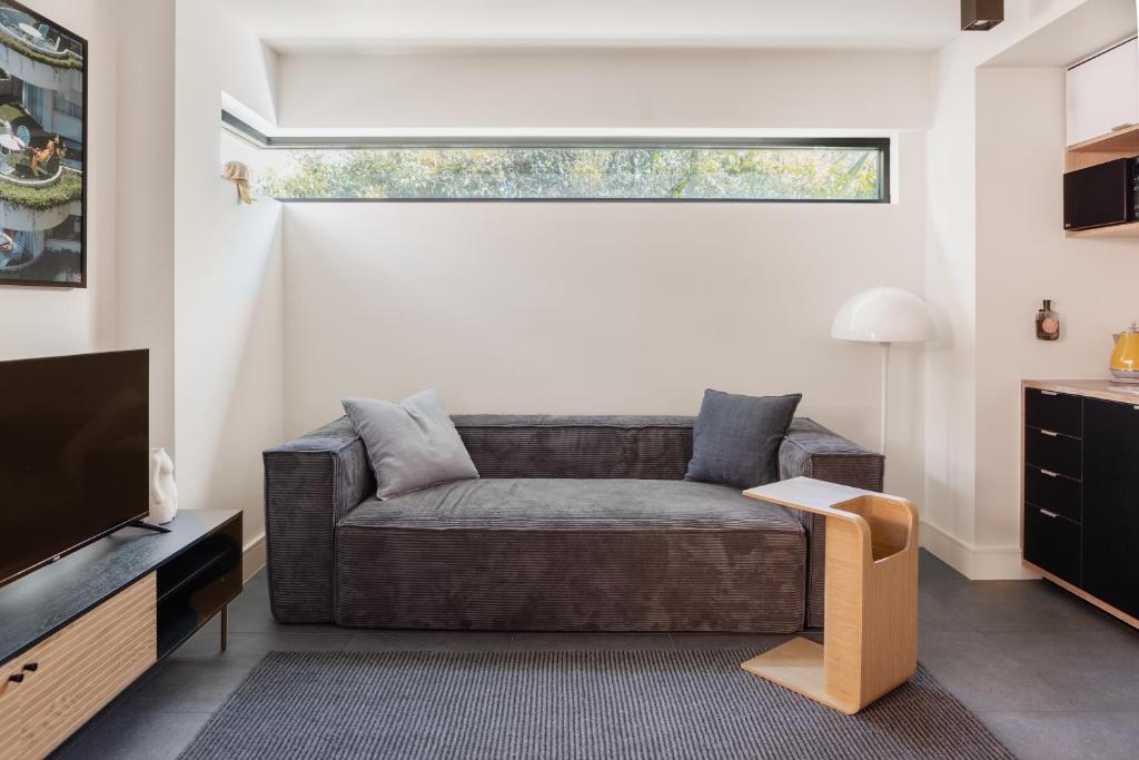 a living room with a couch and a television at MAC Middle Park by Melbourne Apartment Collection in Middle Park