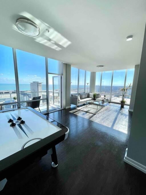 a living room with a table in a room with windows at Penthouse In South Loop Chicago in Chicago