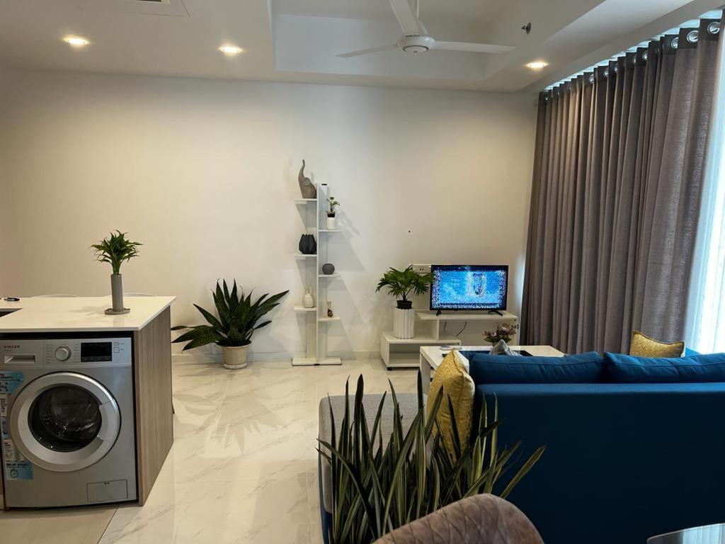 a living room with a blue couch and a washing machine at Luxury Sky Apartment in Colombo