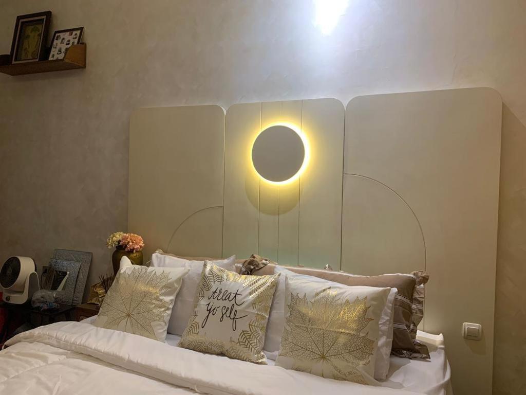 een slaapkamer met een bed met een licht erboven bij Guest House Premium Alaufbee in Jakarta