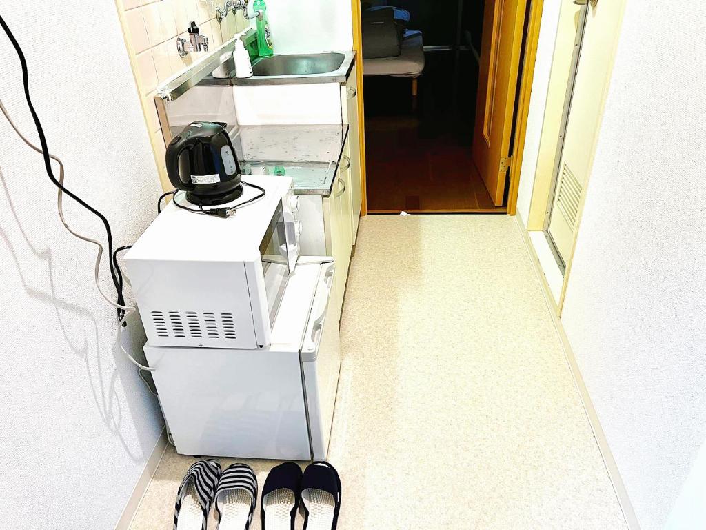 un ordenador sentado en el suelo en una habitación en Shibuya Honmachi Hana House, en Tokio