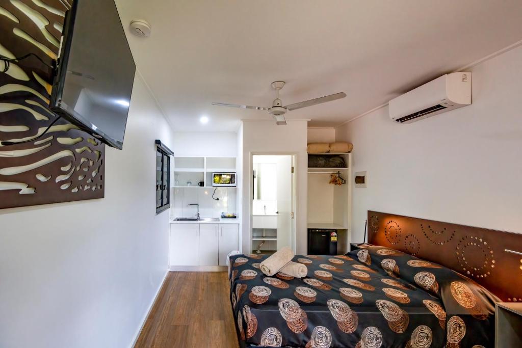 una piccola camera con letto e cucina di Aurora Kakadu Lodge a Jabiru