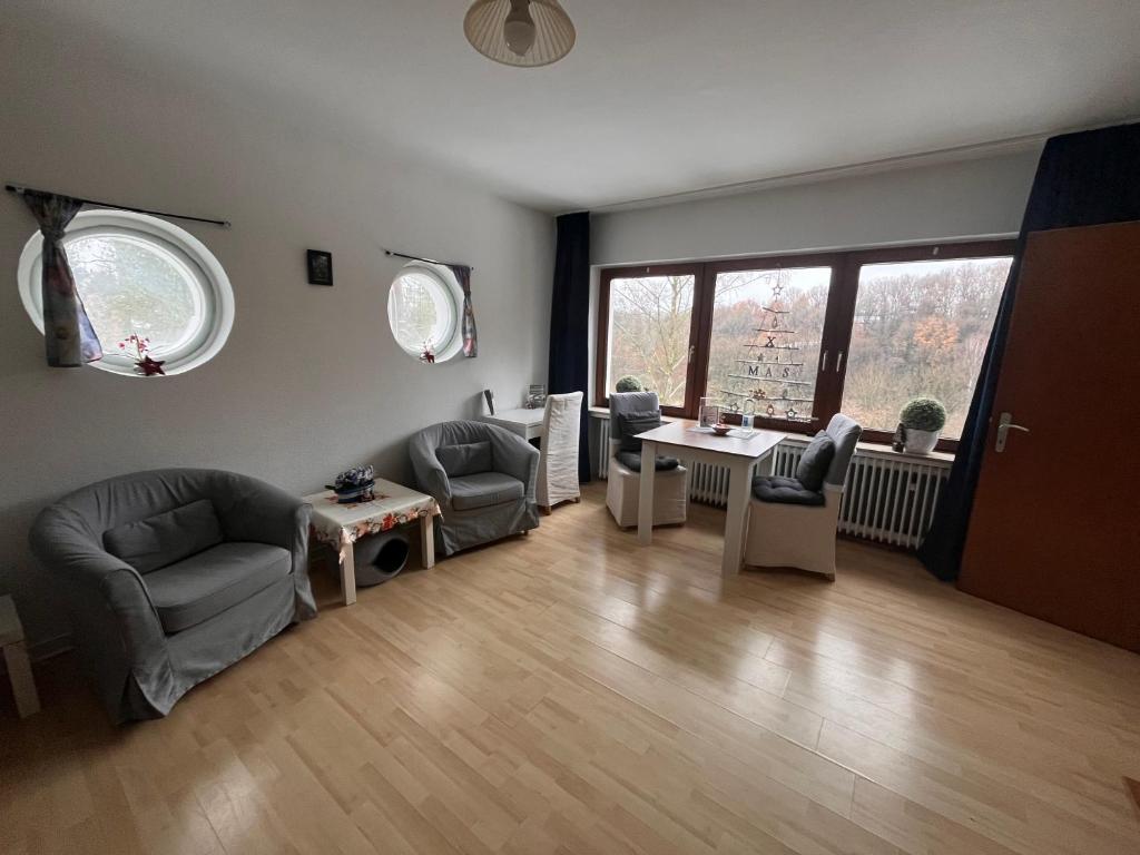 een woonkamer met 2 stoelen en een tafel bij Ferienwohnungen Waldblick in Remscheid