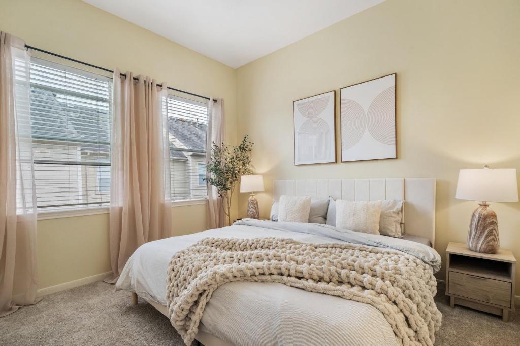 a bedroom with a bed and two windows at Luxury TownHouse Next to Downtown in Houston