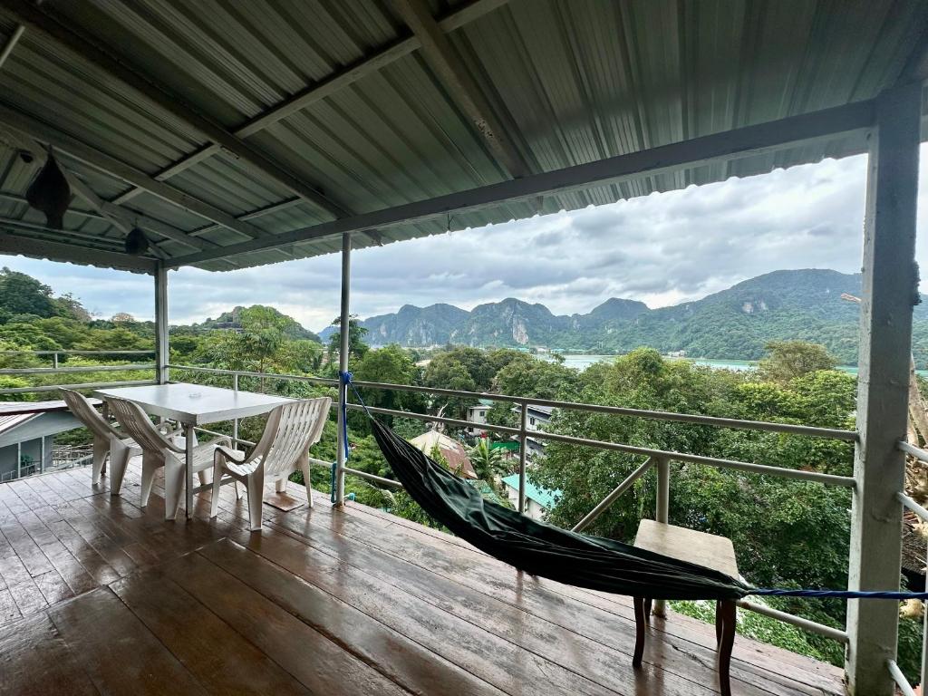 een veranda met een hangmat en een tafel en stoelen bij Hilltop view - Phi Phi in Phi Phi Don
