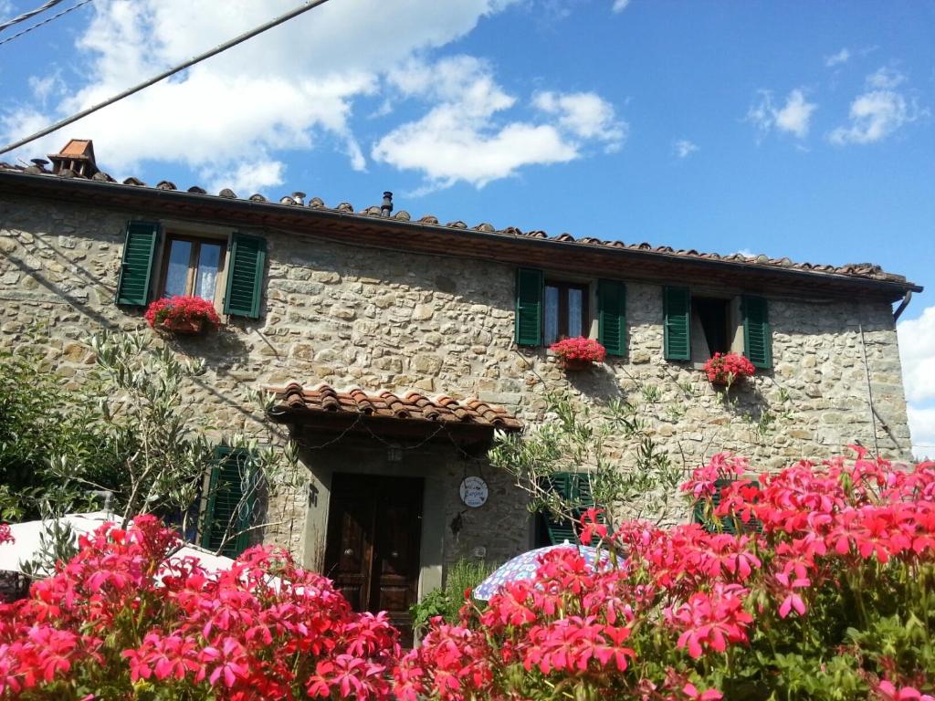 uma casa de pedra com flores em frente em B&B La Margine e SPA em Cocciglia