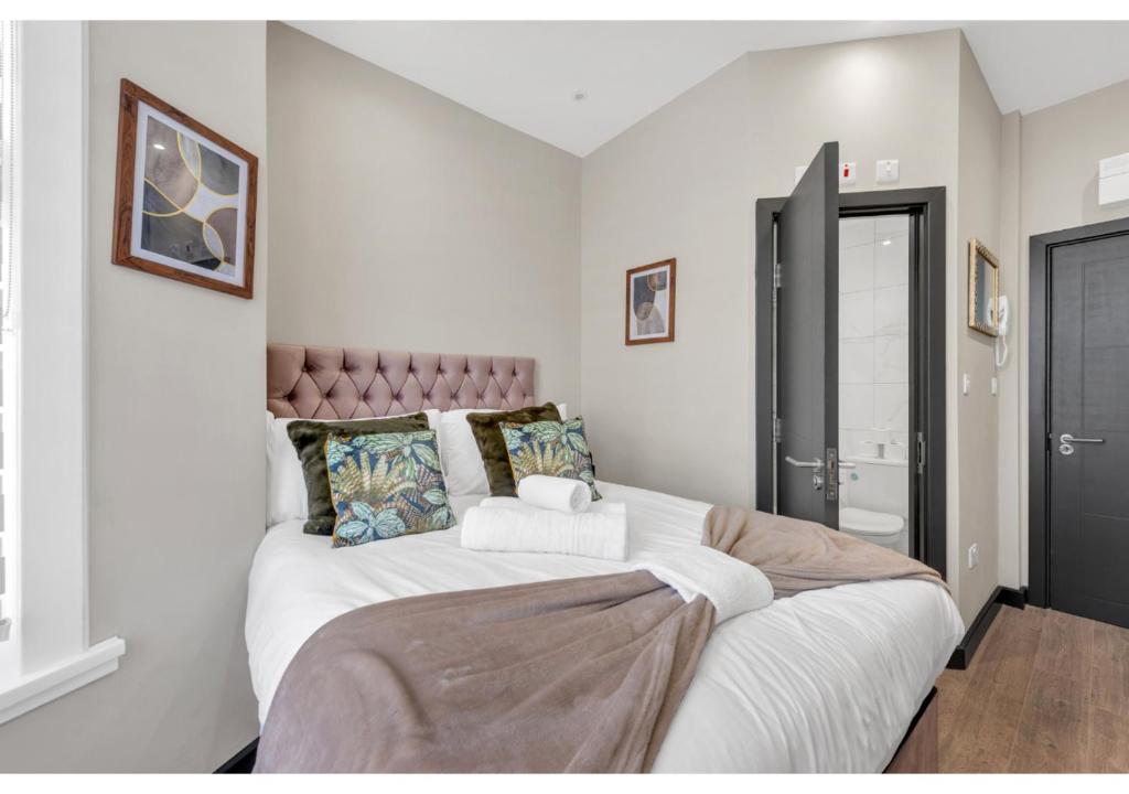 1 dormitorio con 1 cama blanca grande. en Escape the Ordinary: Cozy and Charming Studio, en Londres