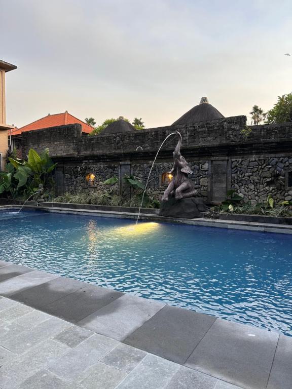 a fountain in the middle of a swimming pool at Warsa's Garden Bungalow and Spa in Ubud