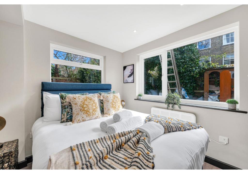 1 dormitorio con 1 cama y 2 ventanas en The Ultimate Hangout Spot: Modern Studio en Londres