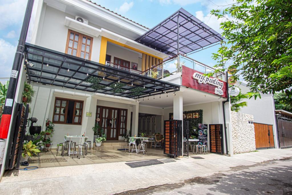 a building with a balcony with tables and chairs at Bisma Balcony Homestay in Jetis