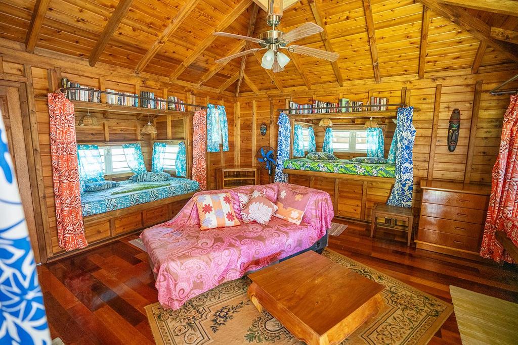 un soggiorno con divano e 2 letti in una cabina di Heimanarii's Lodge - Fare Manu a Haapiti