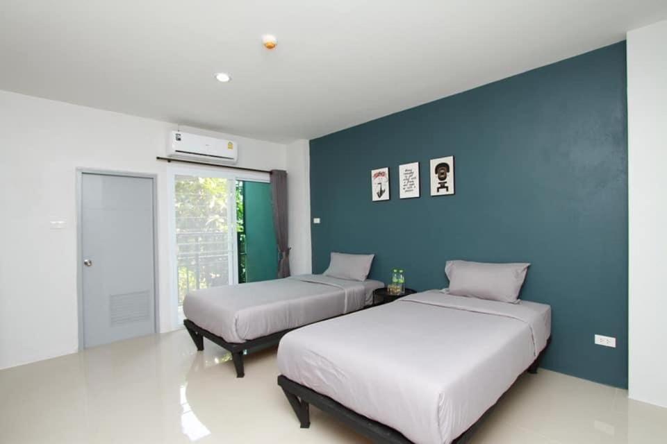 Around Loei في لووي: غرفة نوم بسريرين وجدار ازرق
