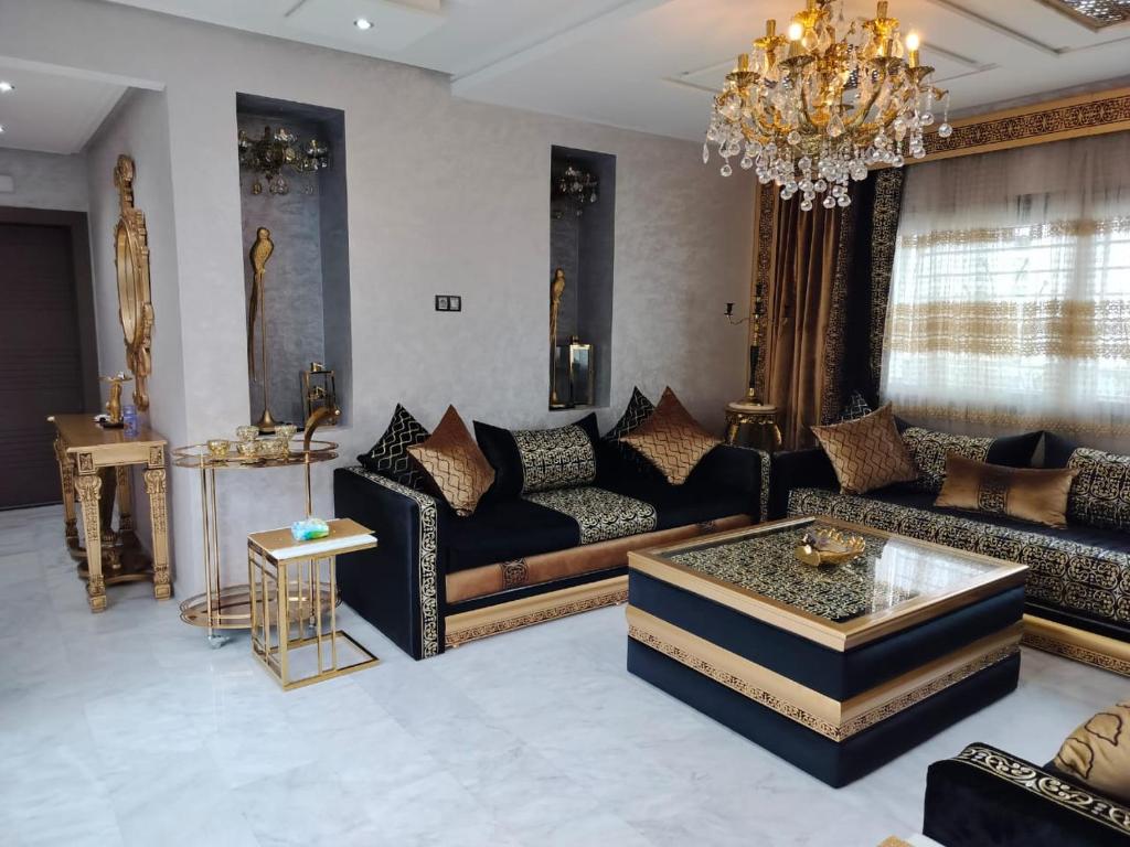 a living room with couches and a chandelier at Housse T in Tangier