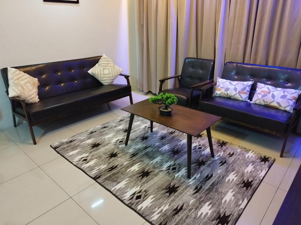 ein Wohnzimmer mit 2 Sofas und einem Couchtisch in der Unterkunft Kinta Riverfront Ipoh - Laaman Homestay in Ipoh