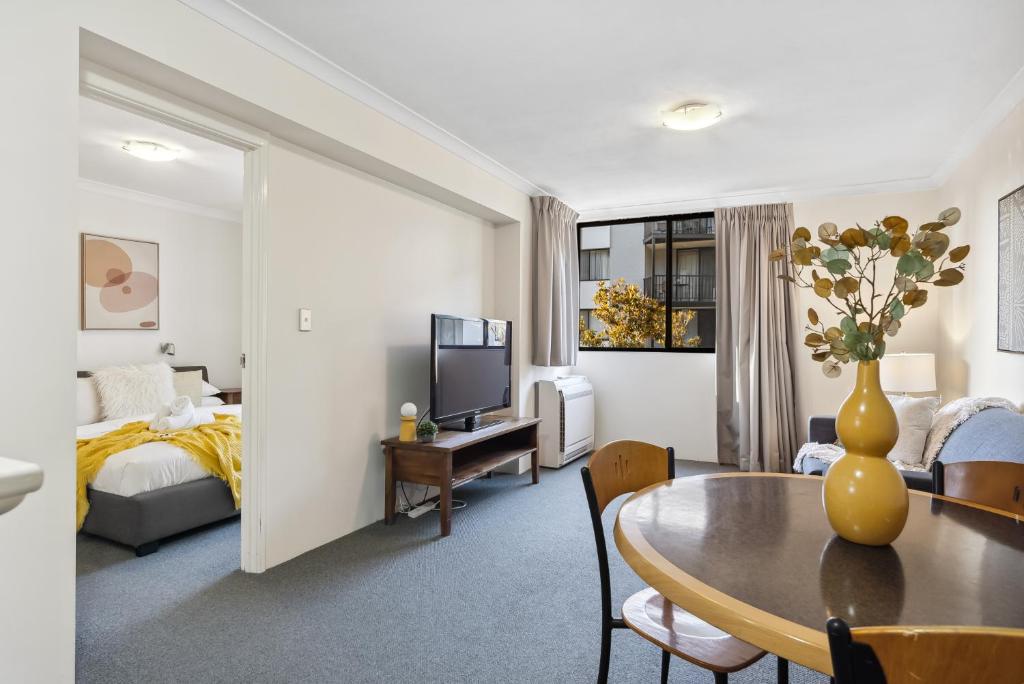 uma sala de estar com uma mesa e um quarto em Riverside Elegance Central 1BR 1BA Apartment em Perth